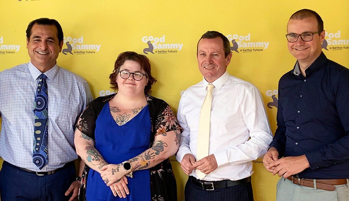 Yaz Mubarakai, Karen (Good Sammy employee), Premier Mark McGowan and CEO Kane Blackman all smiling in front of the Good Sammy logo wall.