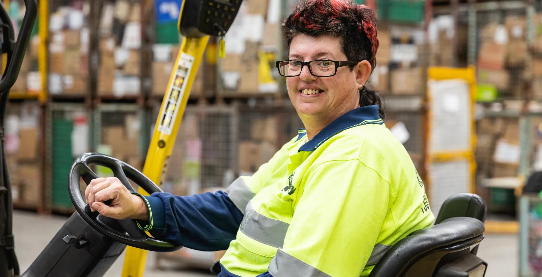 Lady in high-vis sitting on forklift