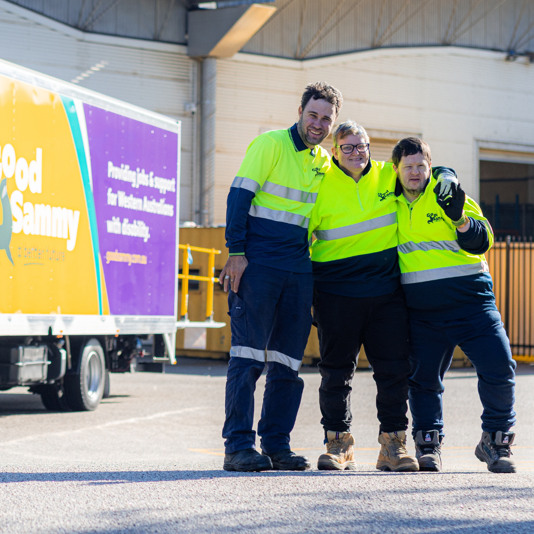 Three employees standing in front of a Good Sammy truck