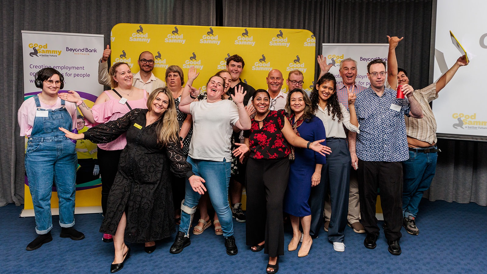 A large group of people with their hands in the air and laughing.